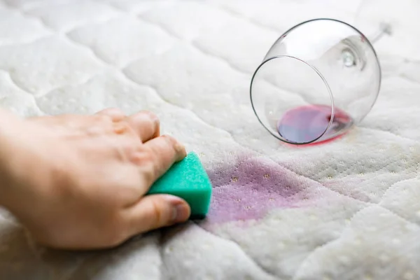 Reiniging wijn vlek met spons. Gemorste wijn op wit laken blad — Stockfoto