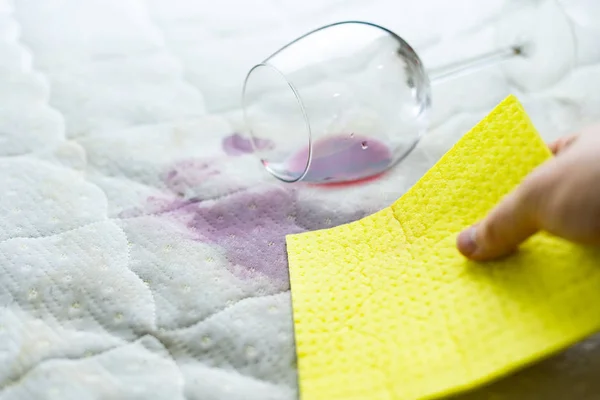 Limpar a mancha de vinho com esponja. Vinho derramado em lençol branco — Fotografia de Stock