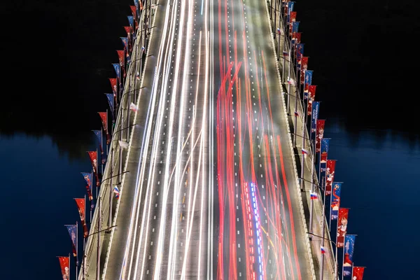 Nizhniy Novgorod / Rússia - 06.16.2018: Ponte rodoviária através do rio. Auto-estrada com faixas de luz do carro. Fotografia de longa exposição . — Fotografia de Stock