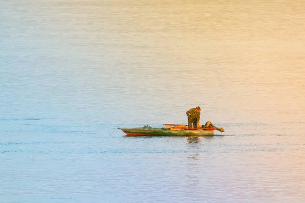 Jediný rybář v zelené lodi. Jezerní krajina. Osamělost — Stock fotografie