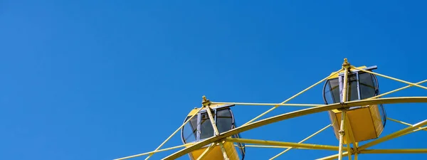 Ferris wheel with yellow cabins. Gladness entertainment in city — Stock Photo, Image