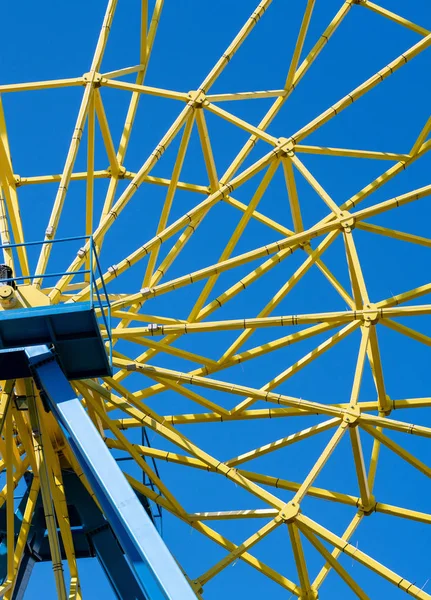Ferris wheel with yellow cabins. Gladness entertainment in city