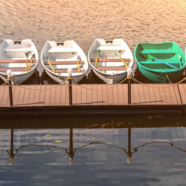 Pier with rowing boats for romantic river walk or fishing. Rowbo — Stock Photo, Image