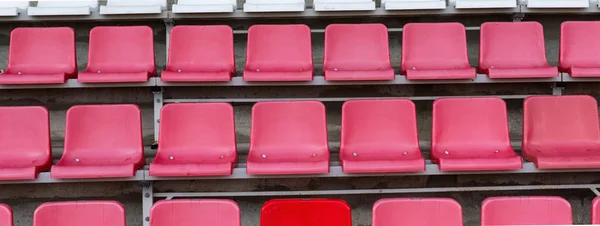 Stadium seats, one seat stands out in red color. Soccer, footbal
