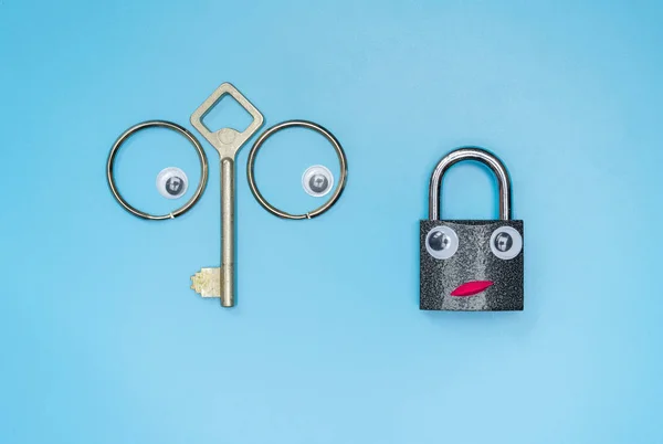 Funny key and lock concept, copy space. Check the security system of your home or business office. Anti thief lock. Blue background.