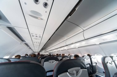 Koltuklar üzerinde uçak klima kontrol paneli. İnsanlarla uçak kabininde hava sızılı hava. Yeni düşük maliyetli havayolu