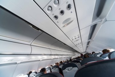 Koltuklar üzerinde uçak klima kontrol paneli. İnsanlarla uçak kabininde hava sızılı hava. Yeni düşük maliyetli havayolu.