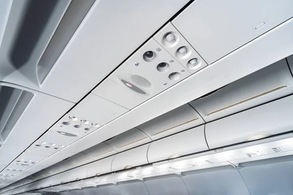Airplane air conditioning control panel over seats. Stuffy air in aircraft cabin with people. New low-cost airline.