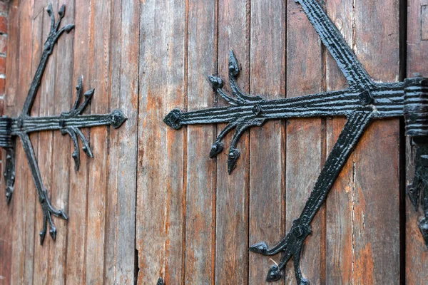 Forged pattern on door with decorative elements. Old vintage entrance, massive heavy wooden door of church or cathedral. — Stock Photo, Image