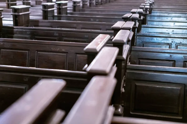 Cathedral benches. Rows of pews in christian church. Heavy solid uncomfortable wooden seats. — Stock Photo, Image