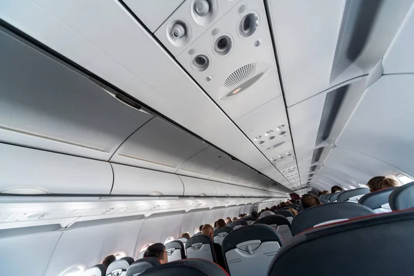 Panel de control de aire acondicionado del avión sobre asientos. Aire tapado en cabina de avión con personas. Nueva aerolínea de bajo coste . — Foto de Stock