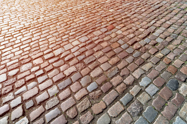 Tiles texture. Pattern of ancient german cobblestone in city downtown. Little granite paving stones. Antique gray pavements.