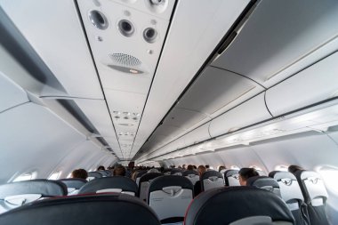 Koltuklar üzerinde uçak klima kontrol paneli. İnsanlarla uçak kabininde hava sızılı hava. Yeni düşük maliyetli havayolu