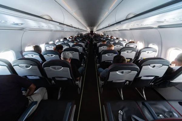 Asientos de cabina de avión con pasajeros. Clase económica de las nuevas compañías aéreas de bajo coste más baratas sin demora o cancelación de vuelo. Viaje a otro país . —  Fotos de Stock