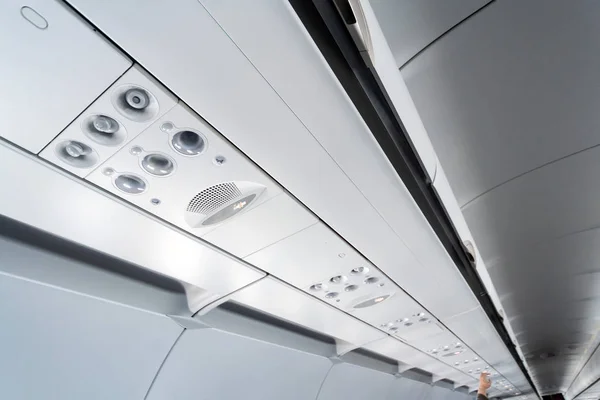 Airplane air conditioning control panel over seats. Stuffy air in aircraft cabin with people. New low-cost airline