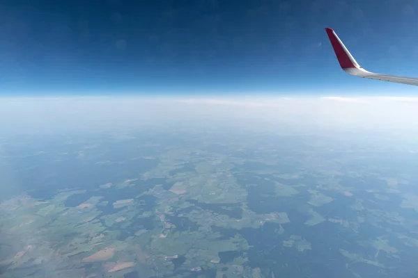 Vista de la ventana del avión al cielo nublado y la tierra. Hermoso paisaje de cabina de avión. Volar sin miedo a volar, incidentes y turbulencias . —  Fotos de Stock