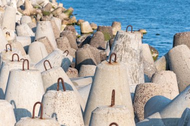 Denizde kırık sular. Fırtına deniz dalgaları, longshore sürüklenme ve hava etkileri kıyı yapıları korumak için beton tetrapodes ile güzel günbatımı deniz manzarası