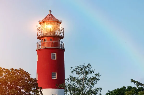 Baltiysk limanında deniz feneri. Güzel gökkuşağı ve işaret ışıkları. Temiz mavi gökyüzü, kopyalama alanı.