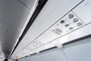 Koltuklar üzerinde uçak klima kontrol paneli. İnsanlarla uçak kabininde hava sızılı hava. Yeni düşük maliyetli havayolu.