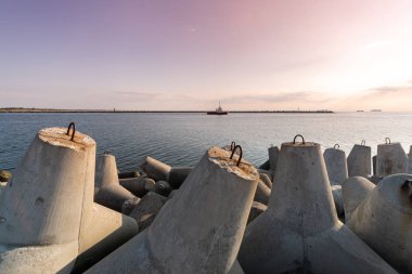 Römorkör denize yelken limana gemi çekme. Tetrapod ara suları limanda. İskele üzerinde güzel gün batımı.
