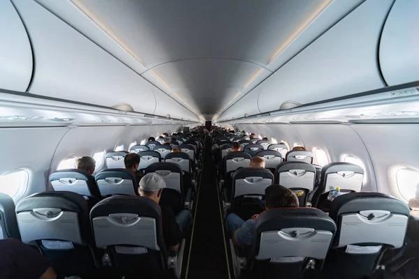 Αεροπορικά καθίσματα καμπίνας με επιβάτες. Οικονομική θέση των νέων φτηνότερες αεροπορικές εταιρείες χαμηλού κόστους χωρίς καθυστέρηση ή ακύρωση της πτήσης. Ταξίδι σε άλλη χώρα. — Φωτογραφία Αρχείου