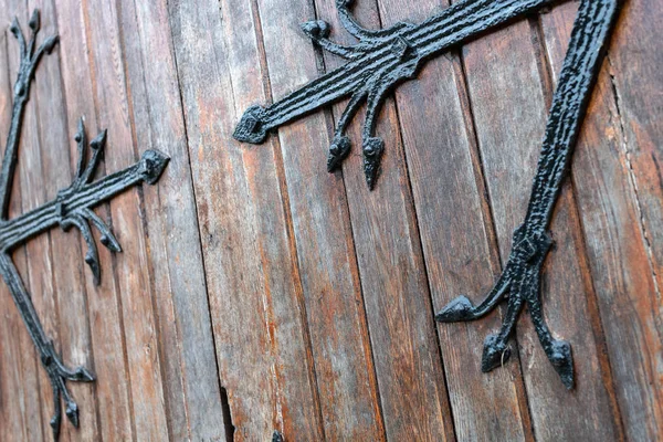 Forged pattern on door with decorative elements. Old vintage entrance, massive heavy wooden door of church or cathedral. — Stock Photo, Image