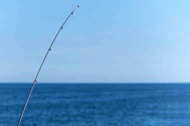 Mavi okyanus veya deniz arka plan karşı Olta, kopya alanı. En büyük vurgunu bekliyorum. Meditative dinlenmek spor.