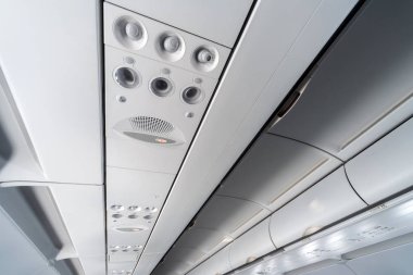 Koltuklar üzerinde uçak klima kontrol paneli. İnsanlarla uçak kabininde hava sızılı hava. Yeni düşük maliyetli havayolu.