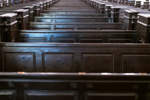 Kathedraal pews. Rijen bankjes in christelijke kerk. Zware massieve, oncomfortabele houten zetels. — Stockfoto