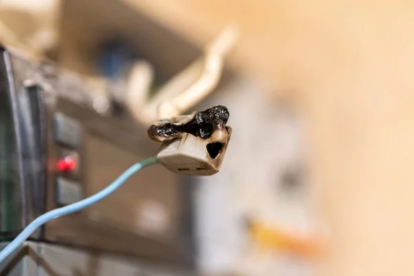 Burned wire, splicing connector, electrical terminal block of nonflammable, fireproof material. Faulty wiring or negligent electrical work. Dangerous short circuit accident.
