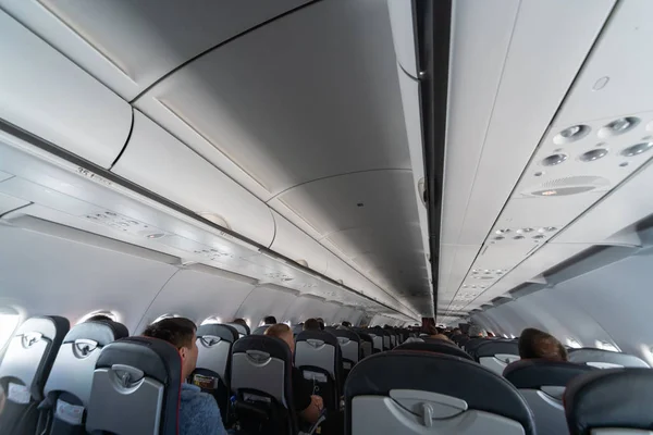 Asientos de cabina de avión con pasajeros. Clase económica de las nuevas compañías aéreas de bajo coste más baratas sin demora o cancelación de vuelo. Viaje a otro país . — Foto de Stock