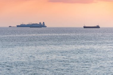 Kargo gemileri ve mavna güzel gün batımında. İnanılmaz akşam deniz manzarası, nefes kesen seyahat manzarası, kopya alanı. Gemiler için demirleme