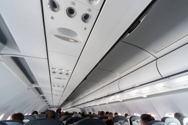 Koltuklar üzerinde uçak klima kontrol paneli. İnsanlarla uçak kabininde hava sızılı hava. Yeni düşük maliyetli havayolu