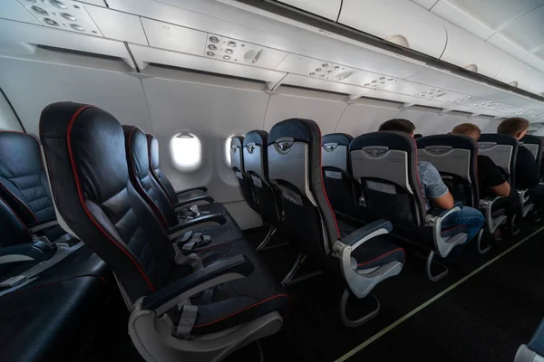 Airplane cabin seats with passengers. Economy class of new cheap