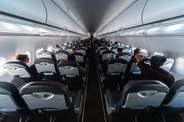 Asientos de cabina de avión con pasajeros. Clase económica de las nuevas compañías aéreas de bajo coste más baratas sin demora o cancelación de vuelo. Viaje a otro país . —  Fotos de Stock