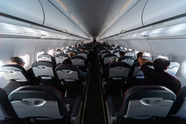 Flugzeugkabinensitze mit Passagieren. Economy Class neuer Billigfluggesellschaften ohne Verzögerungen oder Flugausfälle. Reise in ein anderes Land. — Stockfoto