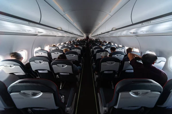 Asientos de cabina de avión con pasajeros. Clase económica de las nuevas compañías aéreas de bajo coste más baratas sin demora o cancelación de vuelo. Viaje a otro país . —  Fotos de Stock