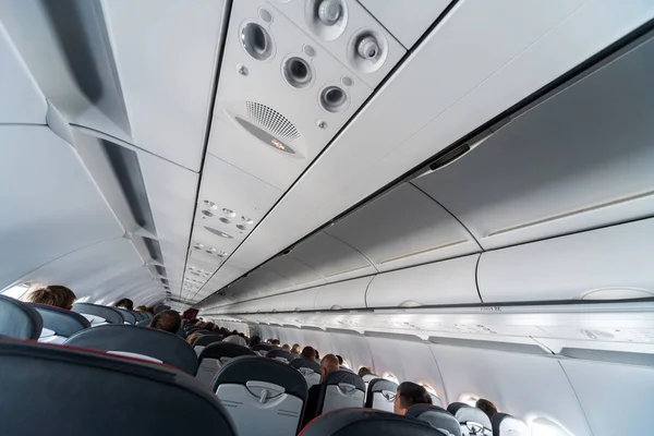 Panel de control de aire acondicionado del avión sobre asientos. Aire tapado en cabina de avión con personas. Nueva aerolínea de bajo coste — Foto de Stock