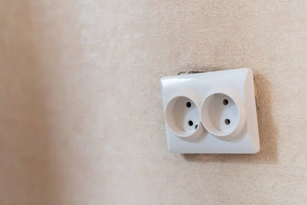 AC power double socket on wall, bad incorrectly installed, copy space. Socket for europlug type. Violations of safety standards. Fire-hazard. — Stock Photo, Image