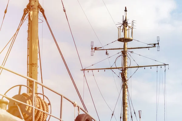 Mastro de navio de fragata, longboat ou navio de guerra da marinha. Mastro de metal. O navio aguarda o capitão nas docas. Velas abaixadas, céu azul no fundo . — Fotografia de Stock