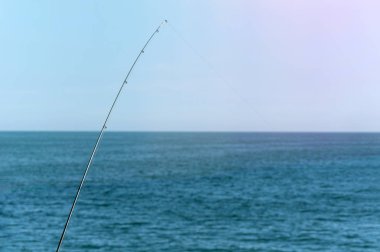 Mavi okyanus veya deniz arka plan karşı Olta, kopya alanı. En büyük vurgunu bekliyorum. Meditative dinlenmek spor.
