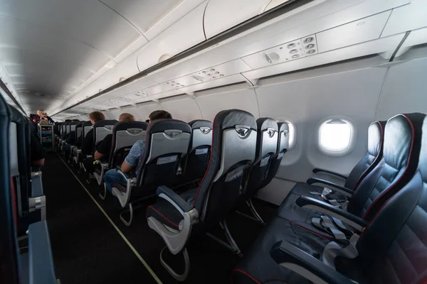 Asientos de cabina de avión con pasajeros. Clase económica de las nuevas compañías aéreas de bajo coste más baratas sin demora o cancelación de vuelo. Viaje a otro país . — Foto de Stock