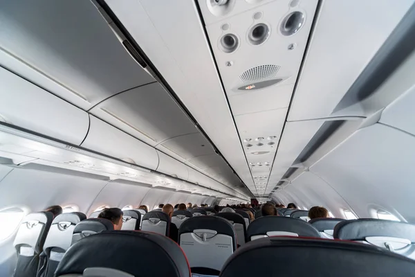 Panel de control de aire acondicionado del avión sobre asientos. Aire tapado en cabina de avión con personas. Nueva aerolínea de bajo coste . — Foto de Stock