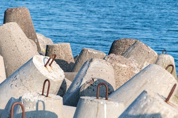 Quebra-mares no mar. Bela paisagem marinha de pôr do sol com tetrápodes de concreto para proteger as estruturas costeiras das ondas do mar de tempestade, efeitos da deriva longshore e clima — Fotografia de Stock