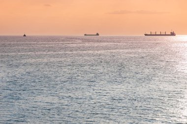 Kargo gemileri ve mavna güzel gün batımında. İnanılmaz akşam deniz manzarası, nefes kesen seyahat manzarası, kopya alanı. Gemiler için demirleme