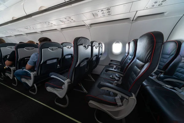 Airplane cabin seats with passengers. Economy class of new cheapest low-cost airlines without delay or cancellation of flight. Travel trip to another country. — Stock Photo, Image