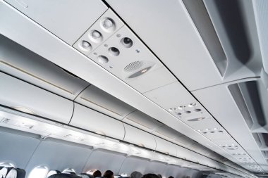 Koltuklar üzerinde uçak klima kontrol paneli. İnsanlarla uçak kabininde hava sızılı hava. Yeni düşük maliyetli havayolu