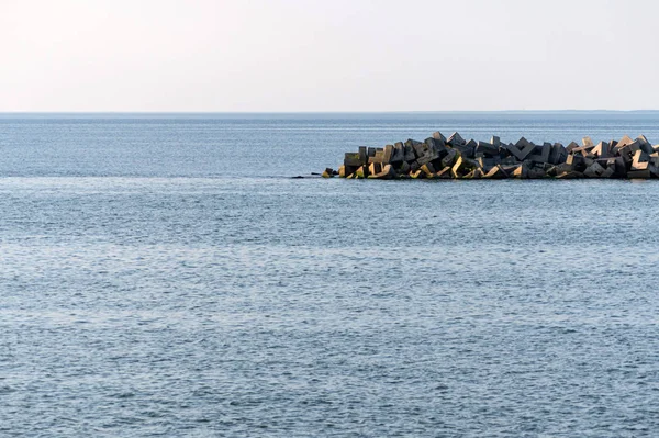 Minimalism seascape. Traveling dreams, copy space. Breathtaking view of sea with breakwaters. Calm blue sea water.