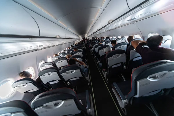 Asientos de cabina de avión con pasajeros. Clase económica de las nuevas compañías aéreas de bajo coste más baratas. Viaje a otro país. Turbulencia en vuelo . — Foto de Stock