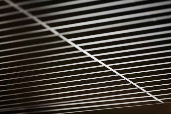 Office grille ceiling. Modern black metal grille ceiling, suspended covering. Abstract design texture.